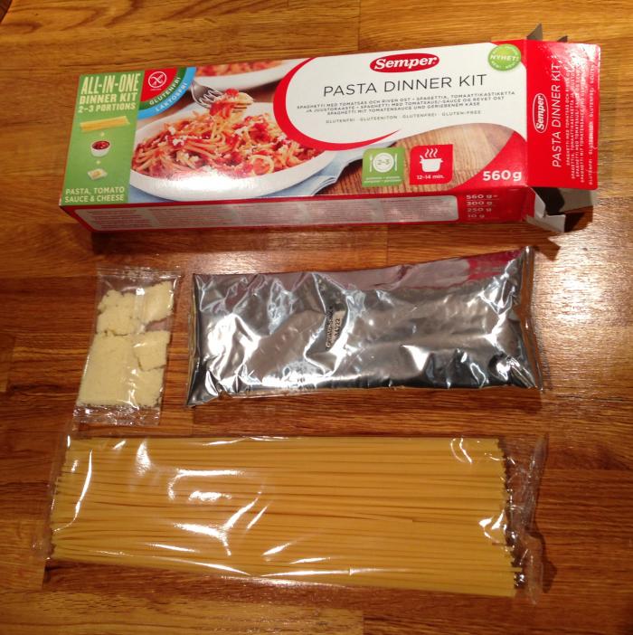 Pasta-ateria sisältää spagettia, kastikepussukan sekä juustoraastetta.